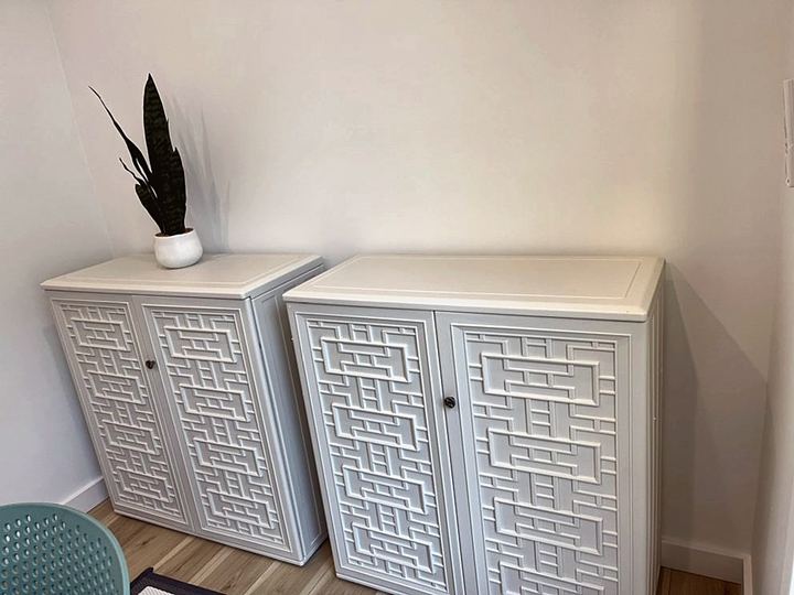 Pair of white cabinets with lattice doors, assembled and leveled