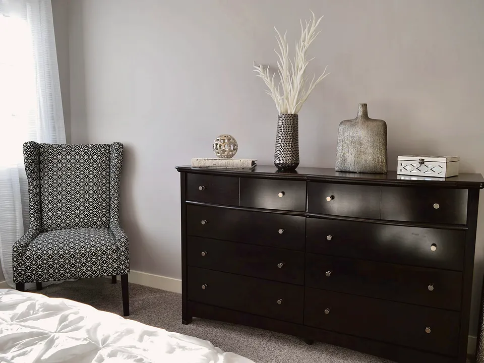 Black dresser against a bedroom wall
