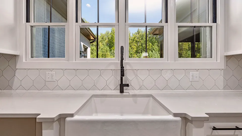 White farmhouse kitchen sink under a window