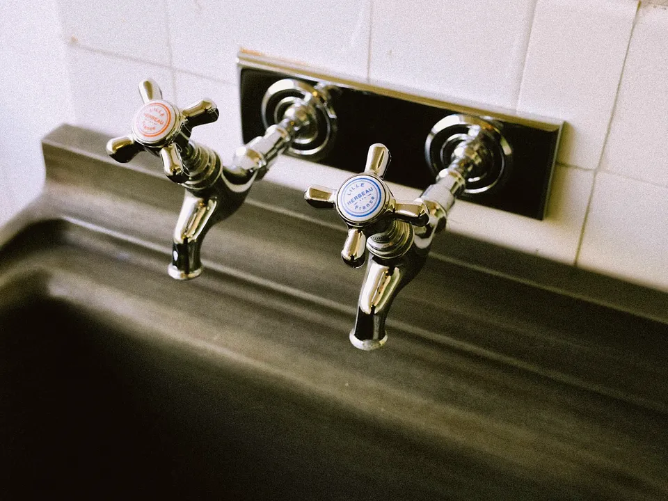 Wall-mounted two-handle faucet over a deep steel sink