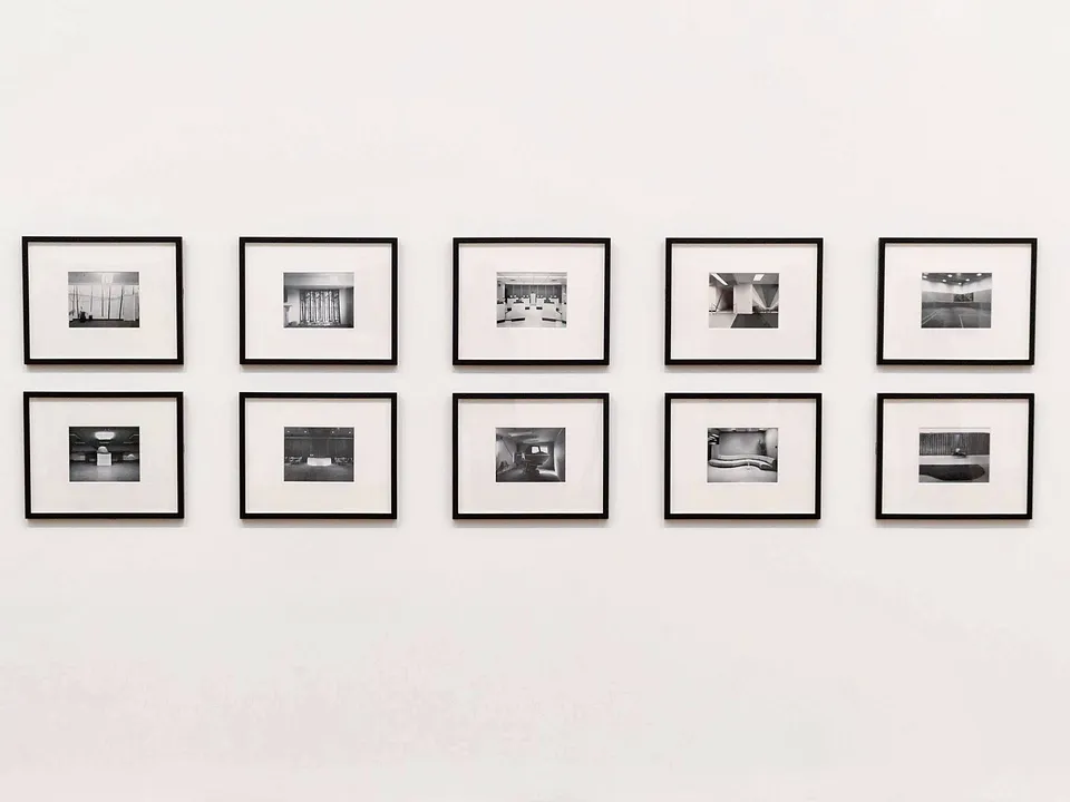 Grid of framed photos hung evenly on a white wall