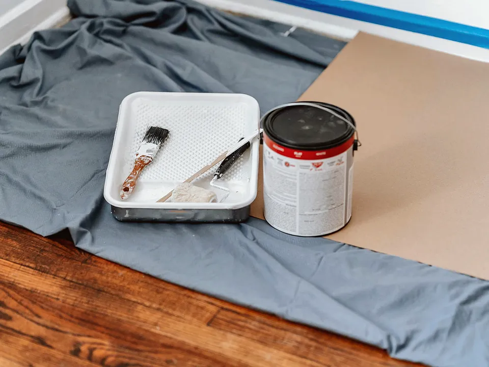Paint can, tray and drop cloth set up for a touch-up