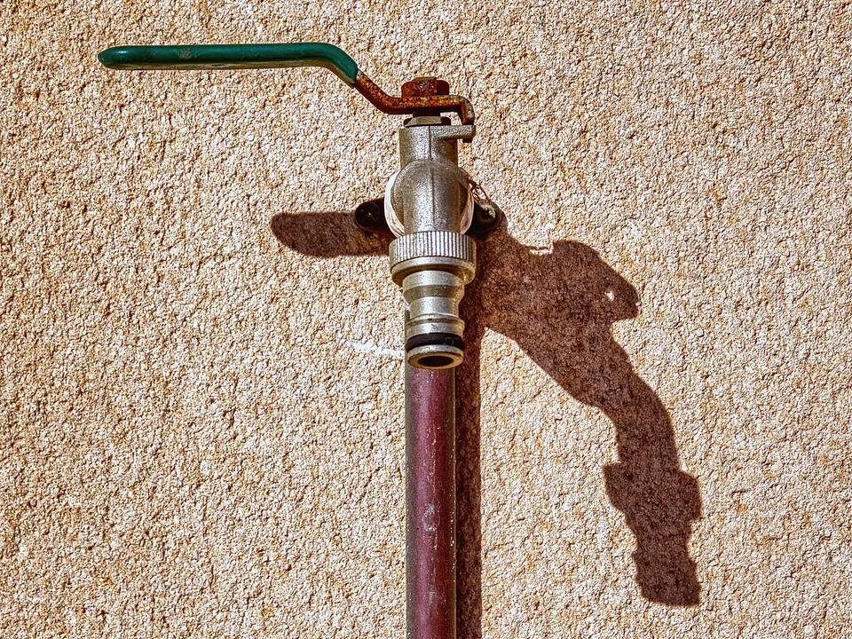 Brass hose valve on a stucco wall