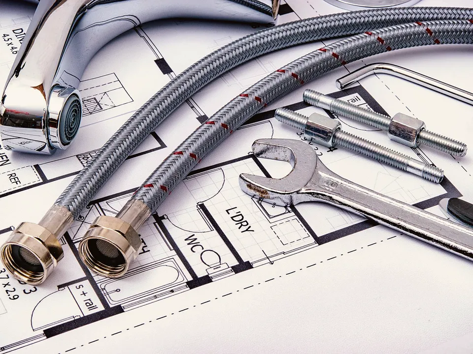 Braided supply lines and wrenches laid out for a faucet install