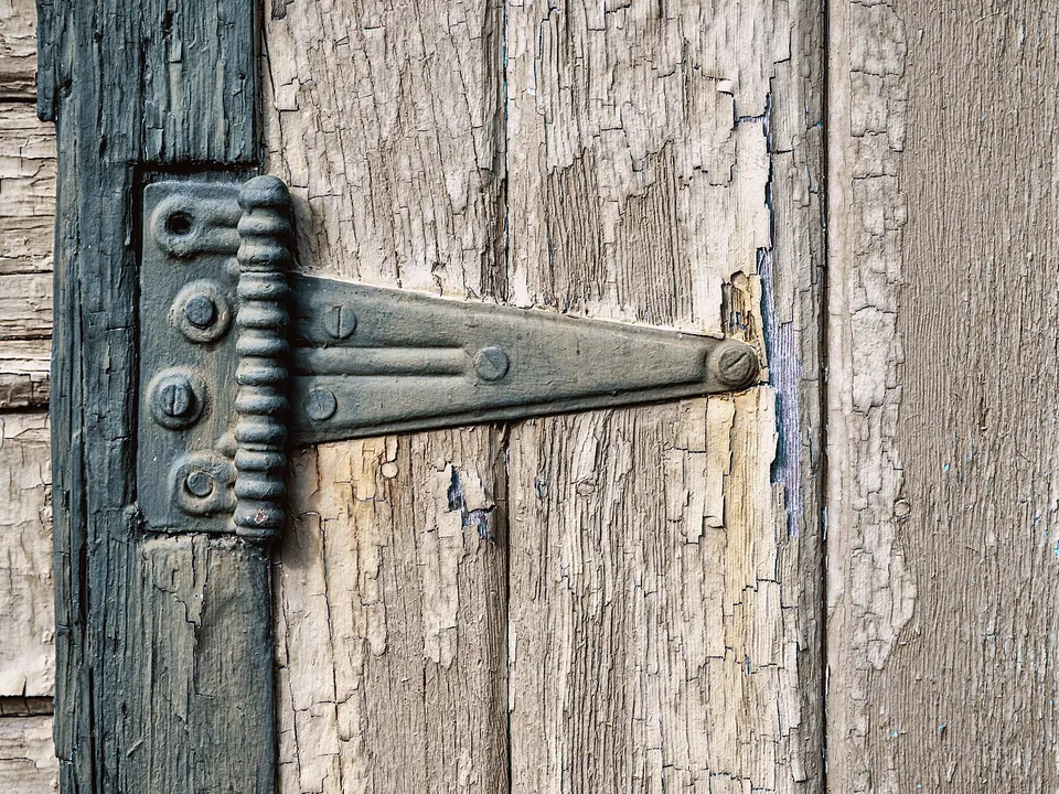 Weathered wood door with a long iron strap hinge