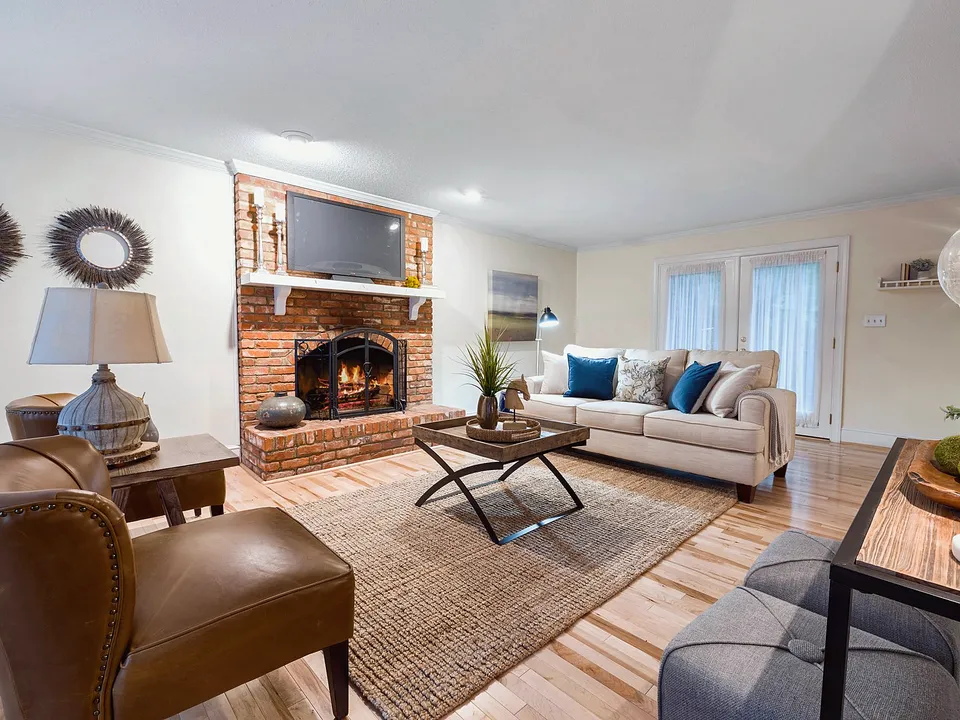 Living room arranged around a brick fireplace