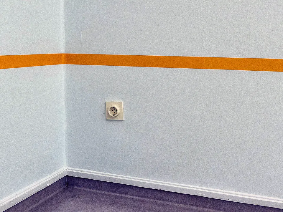 Wall outlet near the floor in a bright room