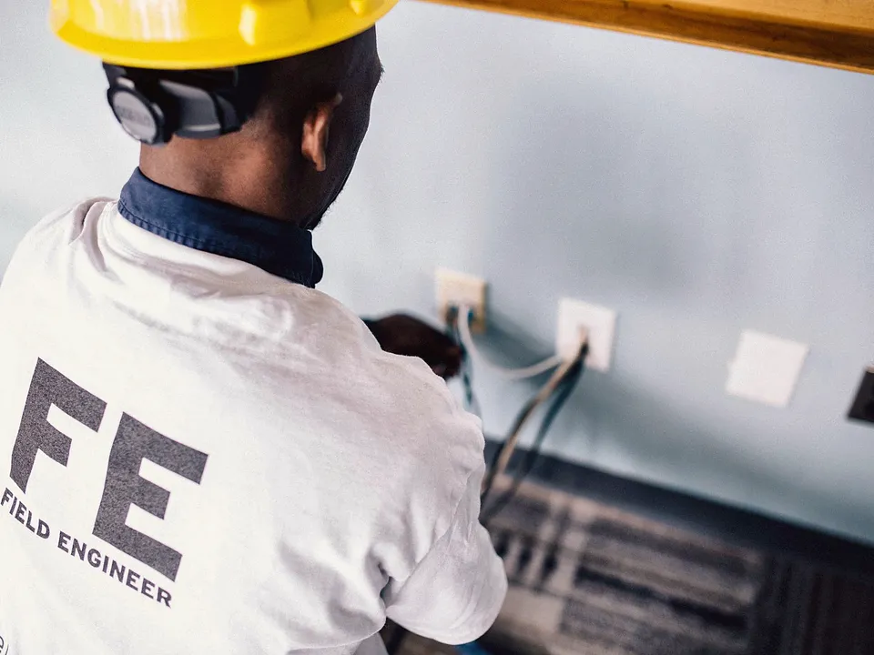 Electrician working on a wall outlet