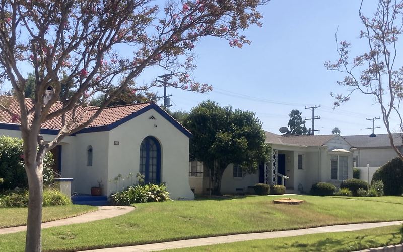 Two Spanish-style homes with front lawns and crape myrtle trees on a residential street in Alhambra