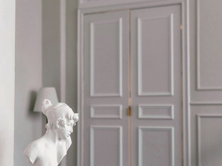 Tall white paneled double doors in a bright room