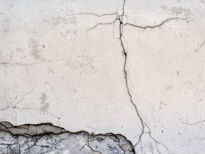 Hairline cracks running across an old plaster wall