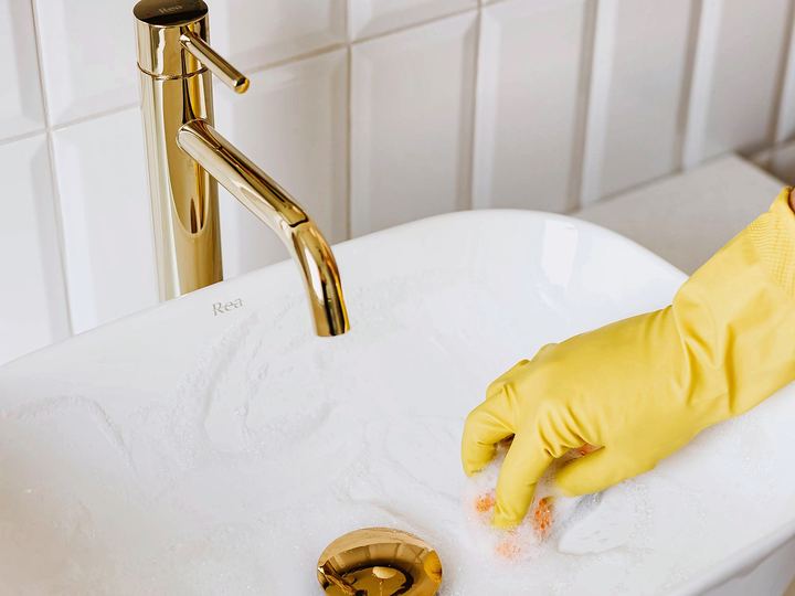 Brushed-gold faucet over a white bathroom sink