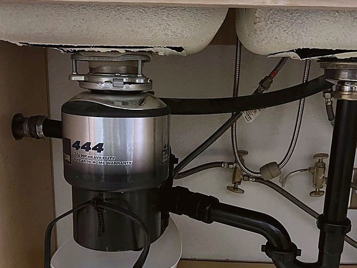 New garbage disposal connected under a kitchen sink