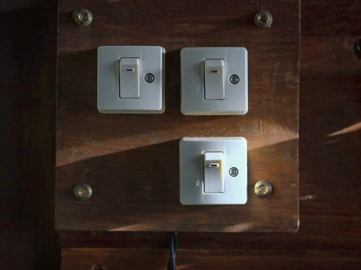 Vintage-style light switches on a wood-paneled wall