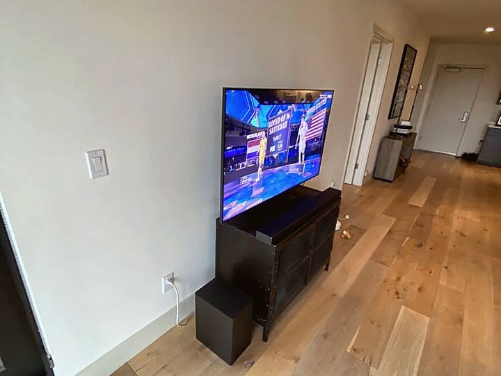Flat-screen TV mounted on a living room wall above a low stand