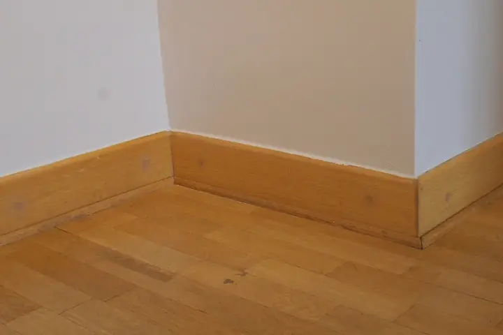 Wood baseboard along a wall and floor