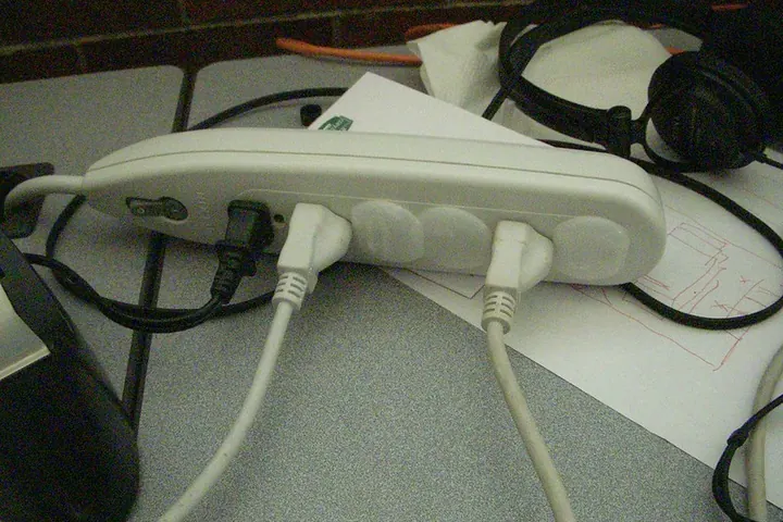 Plastic safety plugs covering the open sockets of a power strip