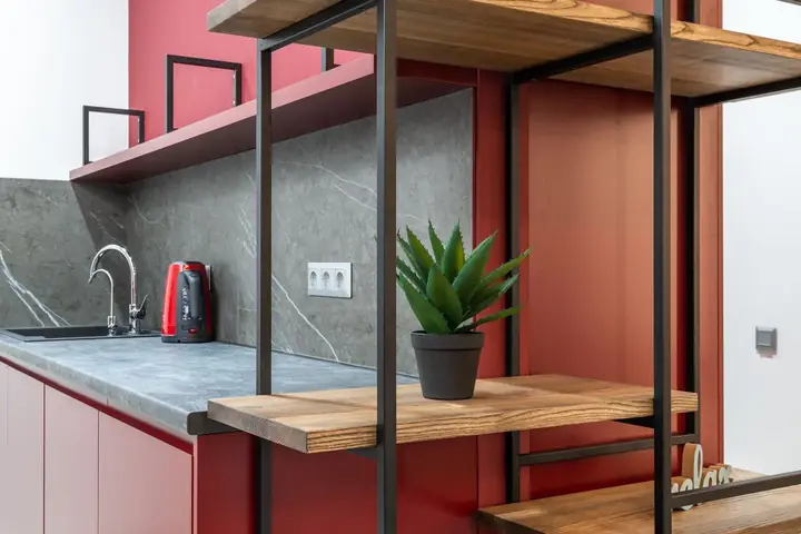 Wood shelves on a black metal frame in a red kitchen