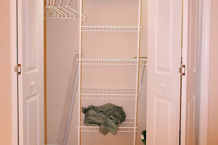 Built-in wall closet with open doors and shelves