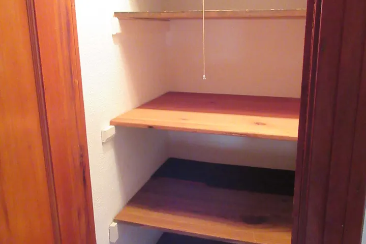 Wooden closet shelves inside a reach-in closet