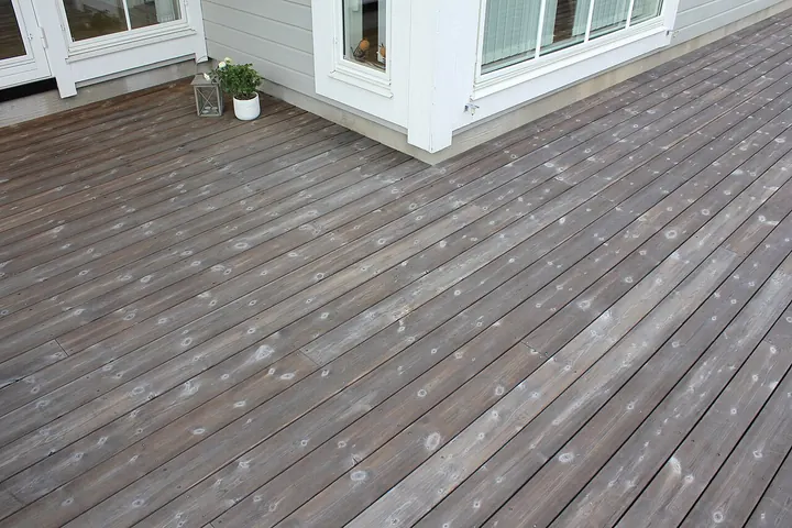 Weathered gray wood deck boards beside a house