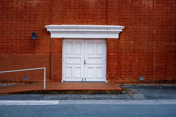 White wooden door on a textured red brick wall