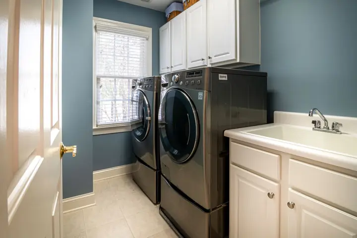 Laundry room with a front-load washer and dryer beside a sink
