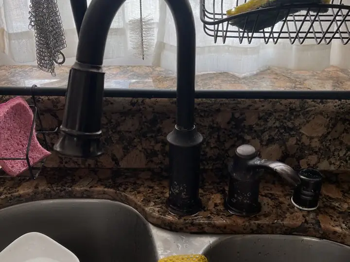 Black pull-down kitchen faucet over a double sink