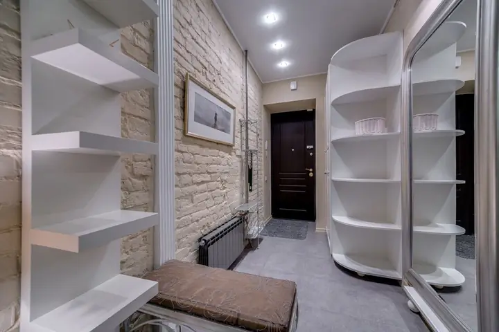 Narrow entry with white open shelves along both walls