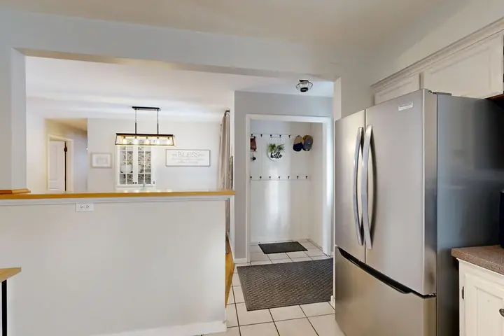 Stainless refrigerator beside a kitchen counter and pass-through