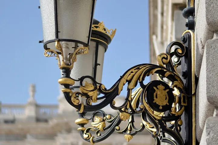 Ornate black and gold wall lantern on a building corner