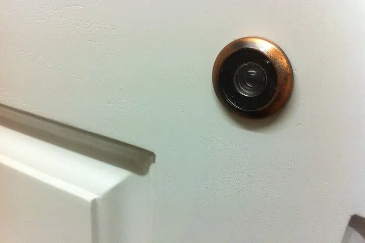 Door viewer installed in a white paneled door