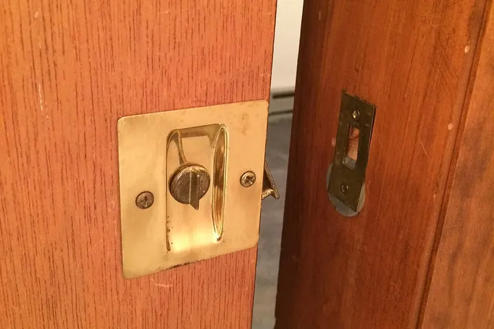 Brass flush pull on the edge of a wood pocket door