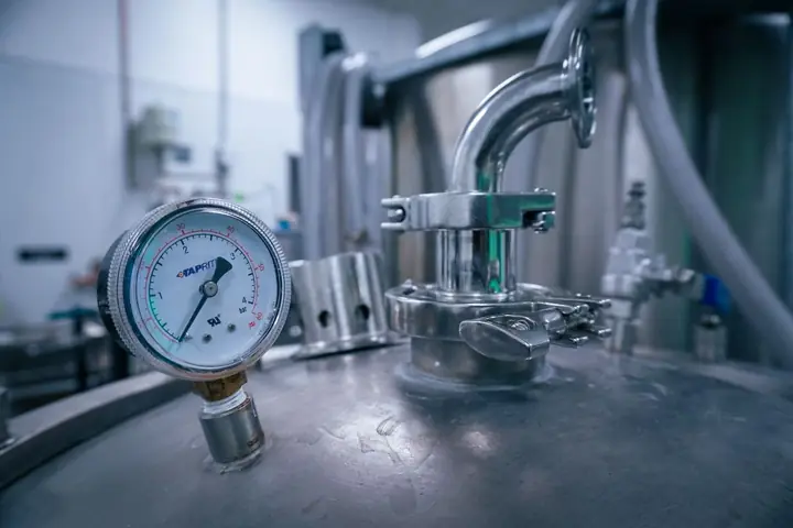 Pressure gauge on top of a steel tank with valves