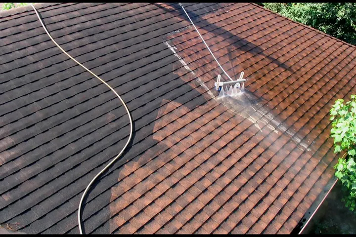 Pressure washer hose resting on a shingle roof