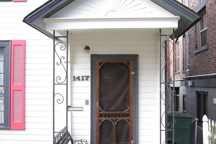 Small front porch with a wooden screen door over the entry