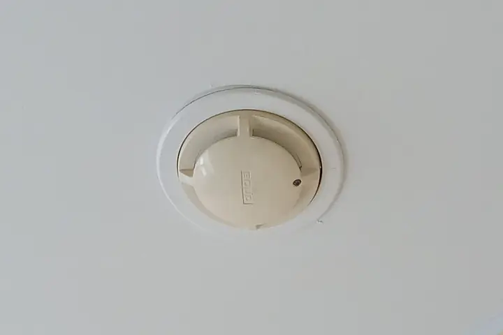 Round smoke alarm on a white ceiling