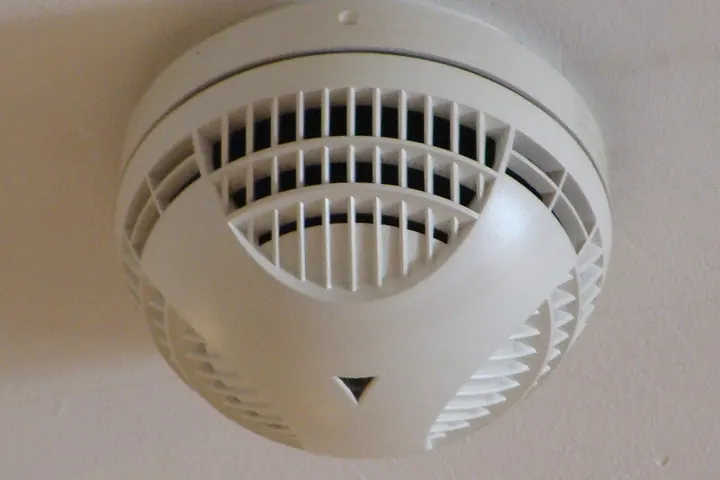 White smoke detector with side vents on a ceiling