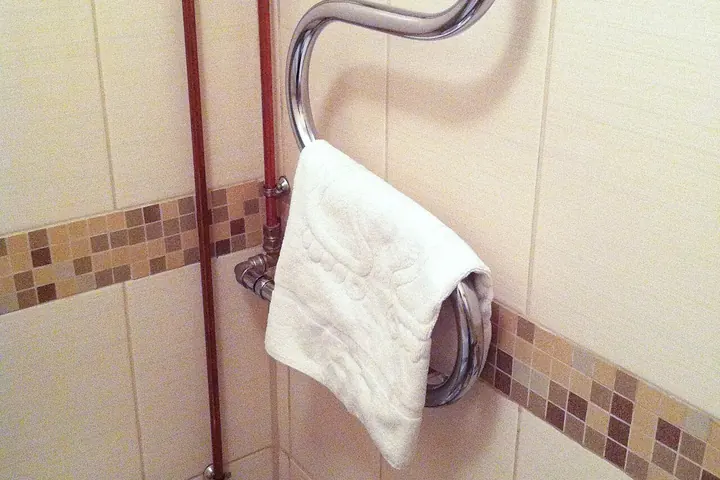 Curved chrome towel ring holding a white towel