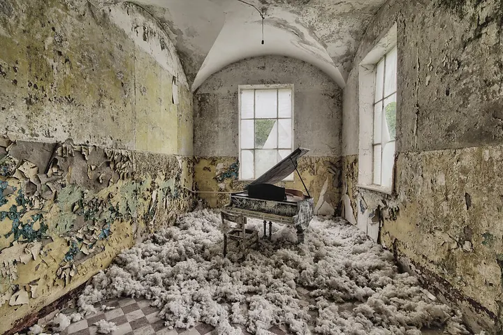 Abandoned room with wallpaper and plaster peeling off