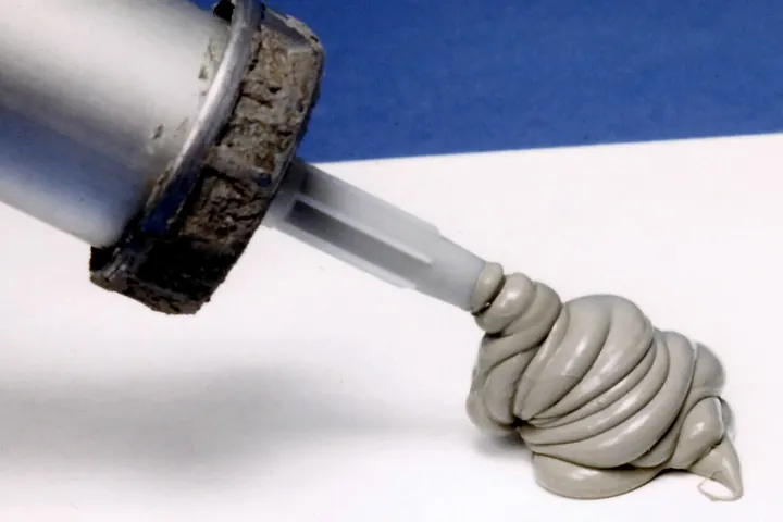 Caulk gun pushing out a bead