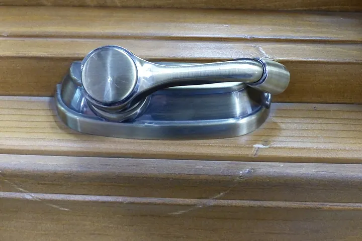 Folding casement window crank handle on a wood window frame