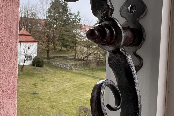 Wrought-iron scroll latch on a casement window