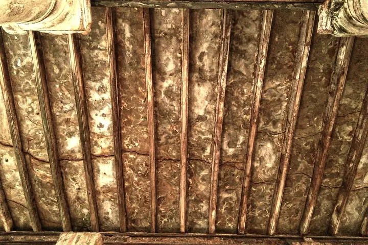 Decayed wooden ceiling boards stained by moisture and rot